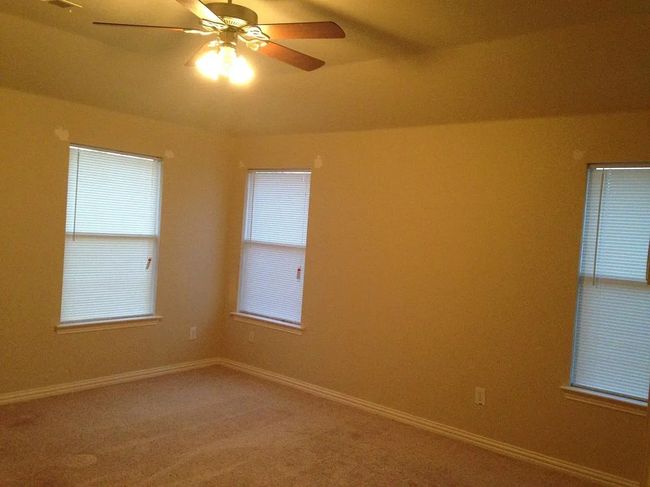 Empty room featuring a ceiling fan and light colored carpet | Image 9