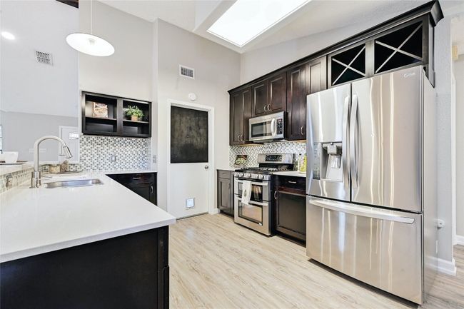 Note the abundance of storage and countertop space along with a 'chalk board' on the doorway leading to garage/laundry, perfect for making a grocery list or leaving a note for your loved one. | Image 13