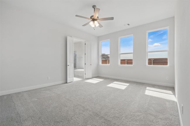 Carpeted spare room with a wealth of natural light, visible vents, baseboards, and a ceiling fan | Image 16