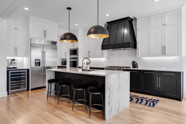 Kitchen with wine cooler, built in appliances, premium range hood, a sink, and backsplash | Image 13