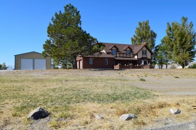 View of front of home featuring a garage and an outdoor structure | Image 1