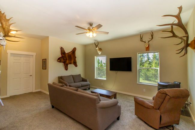 Carpeted living area with a pellet stove, and ceiling fan | Image 5