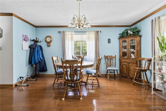 Dining area featuring a chandelier, a textured ceiling, and ornamental molding | Image 21