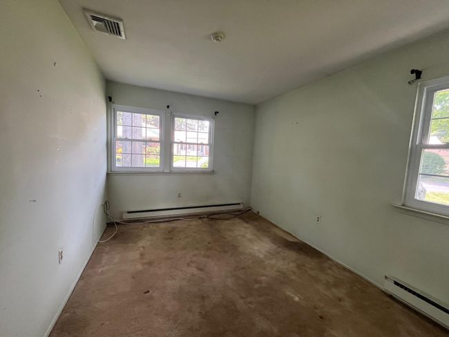 Unfurnished room with a baseboard radiator, a baseboard heating unit, carpet, and a smoke detector | Image 10