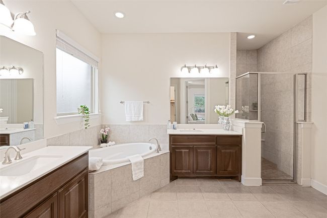 Full bathroom featuring tile patterned flooring, two vanities, a shower stall, a bath, and recessed lighting | Image 22