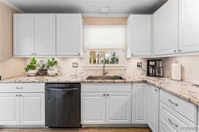 Kitchen with dishwasher, a sink, white cabinetry, and ornamental molding | Image 13