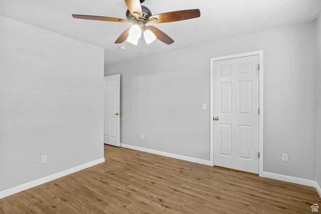 Empty room with wood finished floors, ceiling fan, and baseboards | Image 17