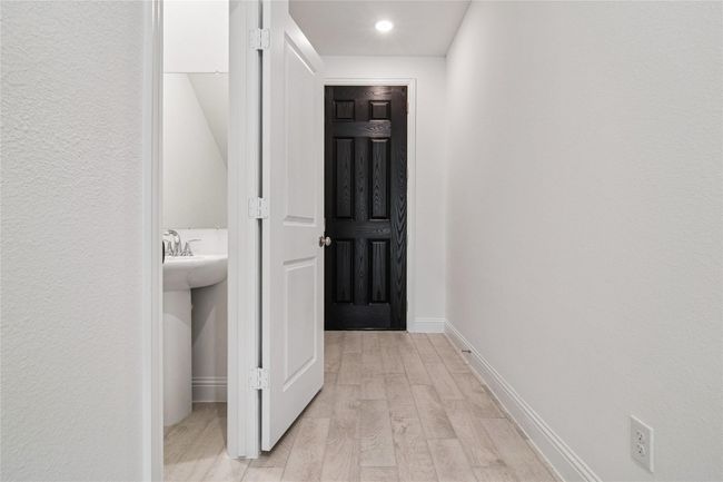 Hall with light wood finished floors, recessed lighting, and a textured wall | Image 29