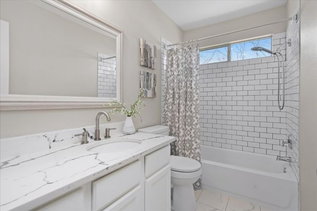 Bathroom featuring vanity, shower / tub combo, toilet, and marble finish floor | Image 28