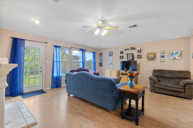 Living area with light wood-style floors, ceiling fan, and baseboards | Image 16
