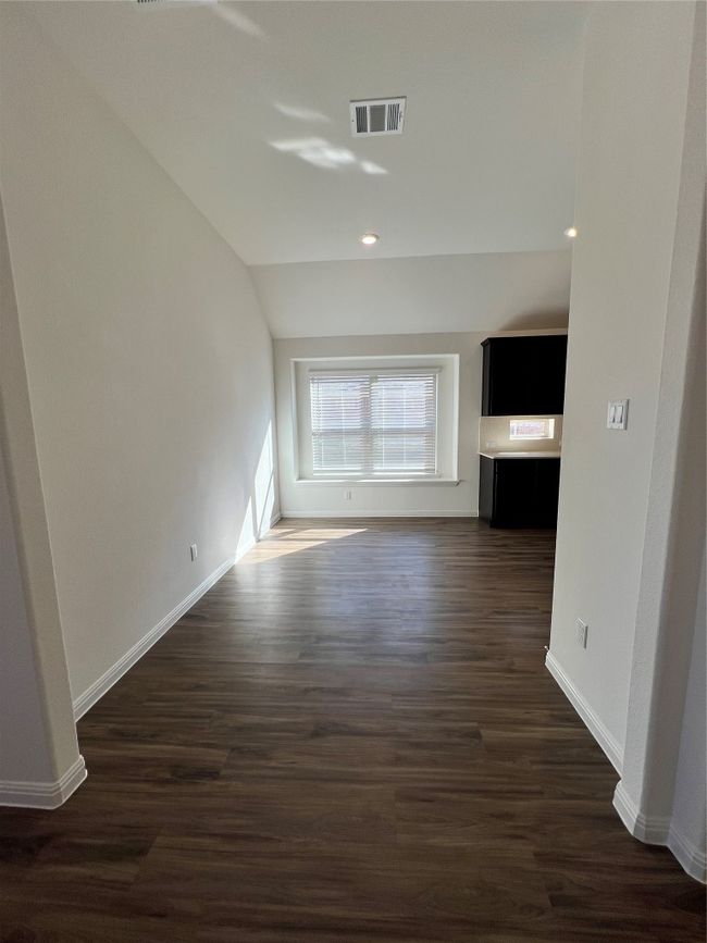 Unfurnished living room with dark wood-style flooring, lofted ceiling, and recessed lighting | Image 8