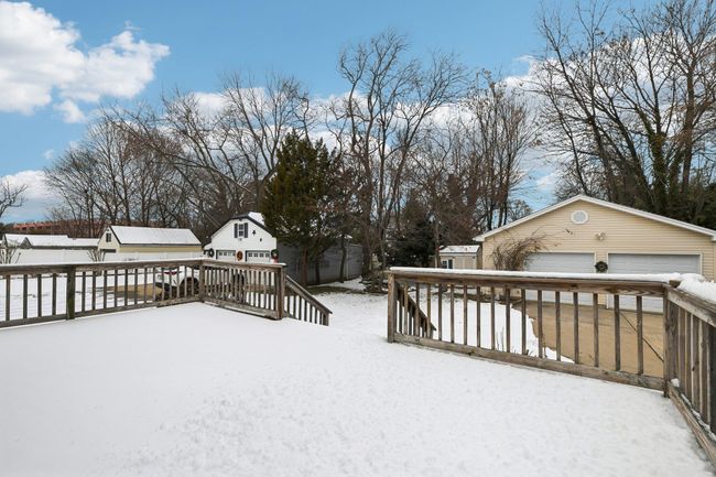 Snow covered deck featuring a garage and an outbuilding | Image 31