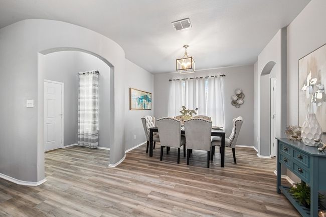 Dining room with light wood-style floors, visible vents, baseboards, and a chandelier | Image 8