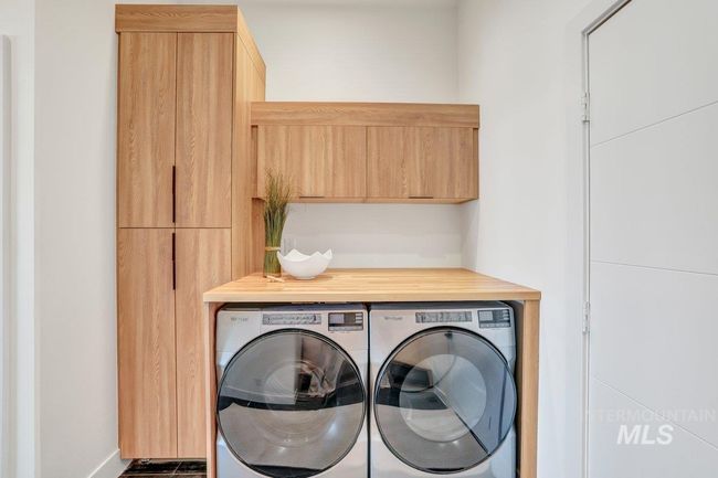 Laundry area with washing machine and clothes dryer and cabinet space | Image 45