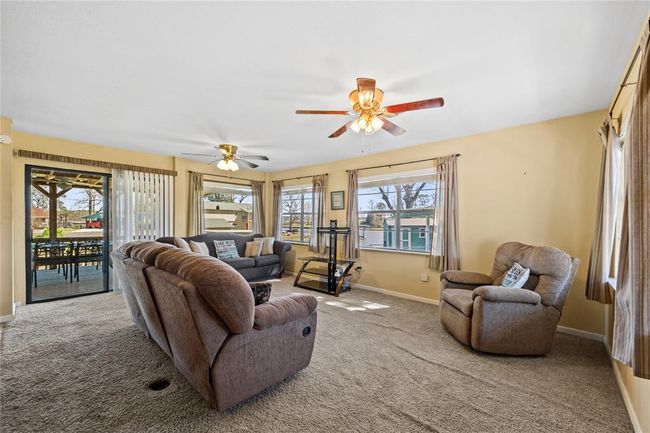 Living room with plenty of natural light, great water views, and doors leading to the covered back deck. | Image 7