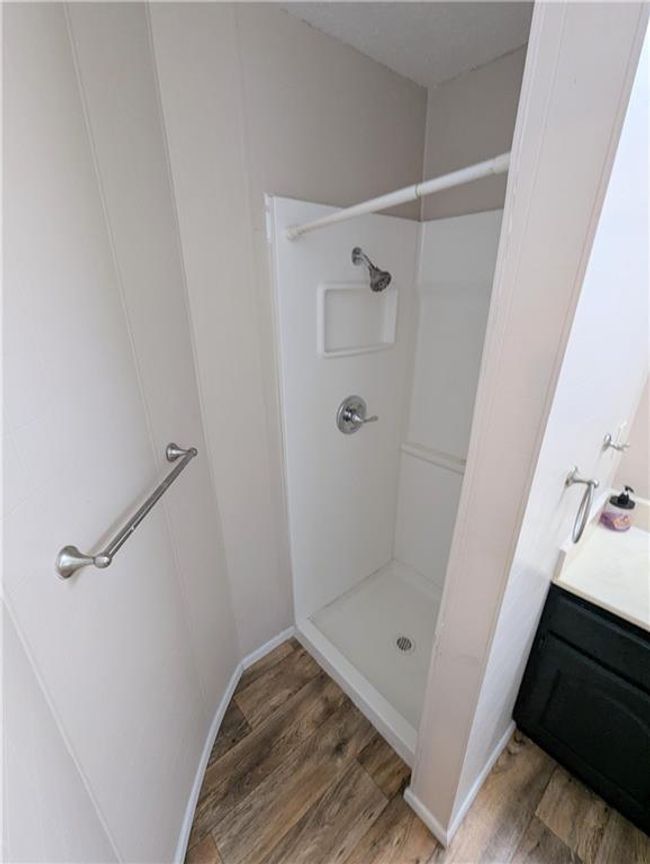 Full bathroom with wood finished floors, a shower stall, and baseboards | Image 27