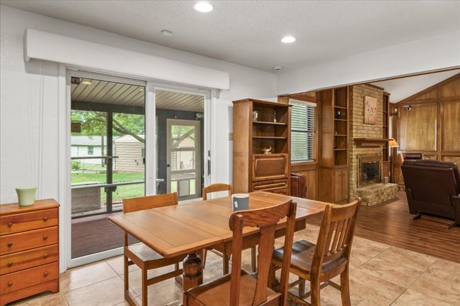 Dining space featuring a fireplace, light tile patterned floors, recessed lighting, and vaulted ceiling | Image 12