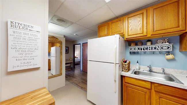 Kitchen featuring freestanding refrigerator, a sink, a drop ceiling, and light countertops | Image 7