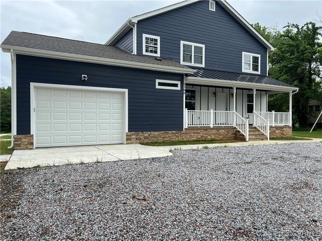View of front of home with covered porch, board and batten siding, a garage, and driveway | Image 31