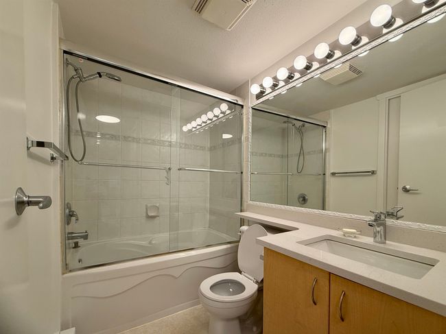 Bathroom featuring vanity and enclosed tub / shower combo | Image 12