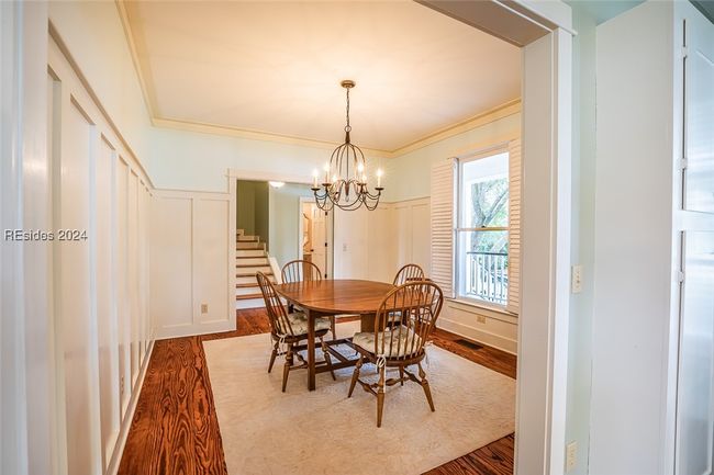 Dining area with hardwood / wood-style flooring, an inviting chandelier, and crown molding | Image 17