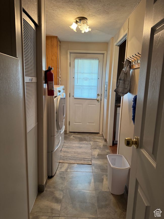 Laundry area with cabinet space, separate washer and dryer, and a textured ceiling | Image 14