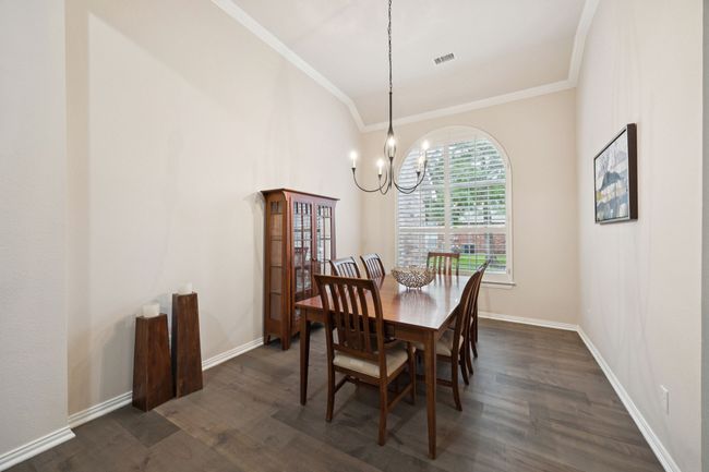 Crowned with a tray ceiling and arched window, this formal dining area offers a peaceful front-facing view and plenty of room for hosting holiday dinners or celebrations. | Image 13