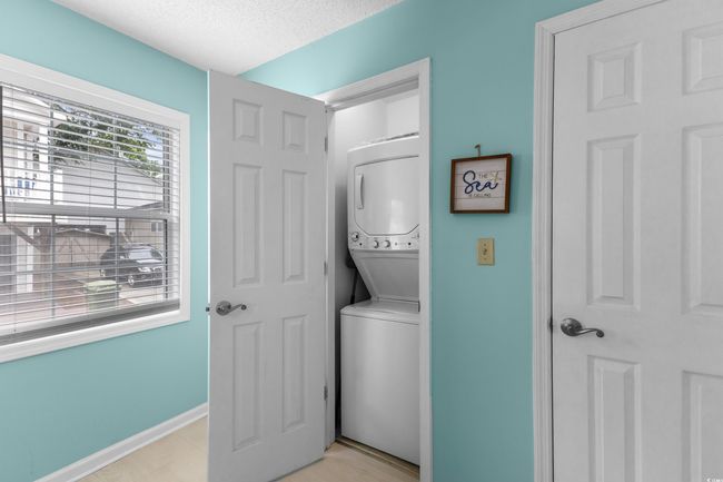Laundry area with stacked washer / drying machine, a textured ceiling, and baseboards | Image 22