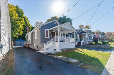 Bungalow featuring a porch, a storage unit, and a front yard | Image 2