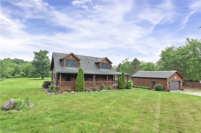 Log-style house featuring covered porch, front yard, 2-car garage and stone drive | Image 50