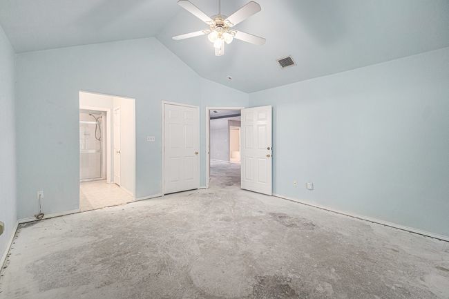 Primary bedroom with view of ensuite bathroom entry. Walk-in closet to the right behind closed door. | Image 11