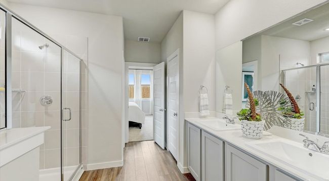 Bathroom with wood finished floors, a stall shower, double vanity, ensuite bathroom, and baseboards | Image 16