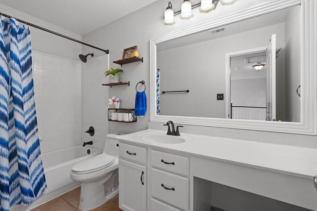Full bathroom featuring tile flooring, shower / bathtub combination, and long vanity. | Image 33