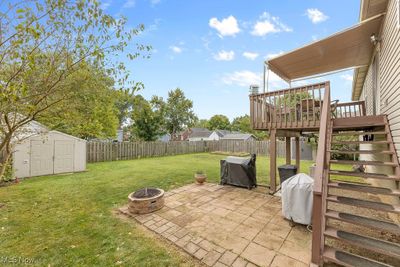 View of yard with a wooden deck, a patio area, a storage shed, and an outdoor fire pit | Image 3