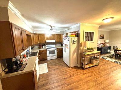 Kitchen featuring wood-type flooring, ornamental molding, white appliances, and ceiling fan | Image 3