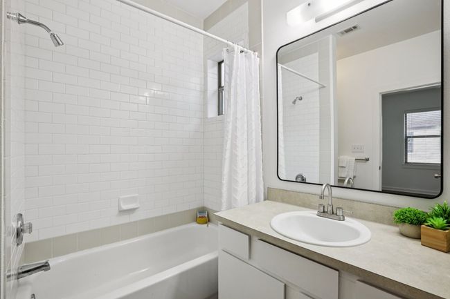 Bathroom featuring shower/tub combo with subway tile and a vanity. | Image 28