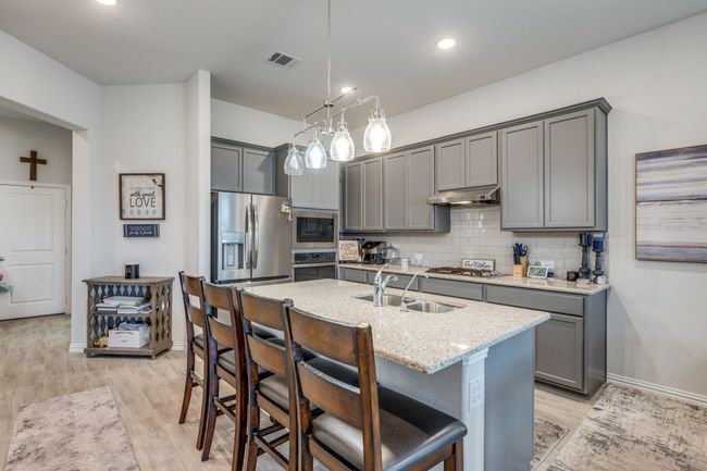 Kitchen featuring gray cabinetry, appliances with stainless steel finishes, a sink, and recessed lighting | Image 6