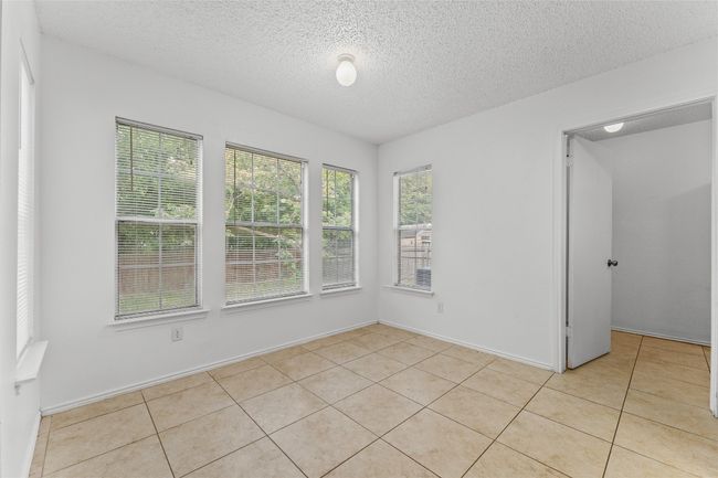 Unfurnished sunroom featuring a textured ceiling and tile patterned floors | Image 17
