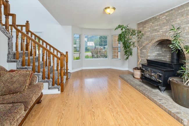 Living Room 2 Interio featuring brick wall, a wood stove, and light wood-type flooring | Image 13