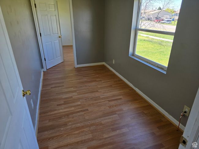 Spare room featuring wood finished floors and baseboards | Image 5