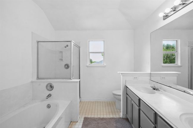 Full bathroom with a stall shower, a sink, lofted ceiling, and a garden tub | Image 21