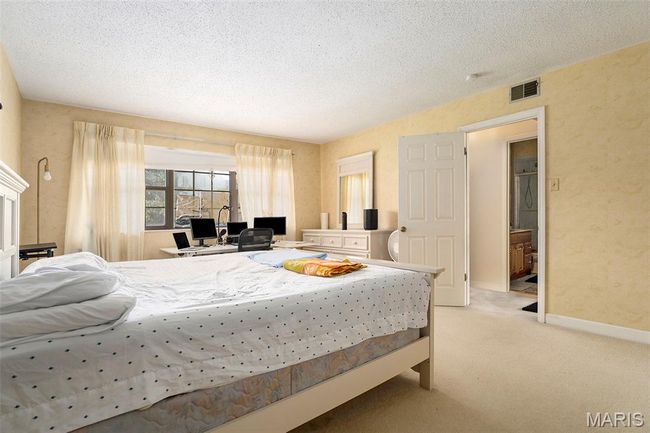 Bedroom featuring light colored carpet and a textured ceiling | Image 14