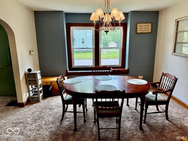 dining space featuring arched walkways, healthy amount of natural light, and a chandelier | Image 13