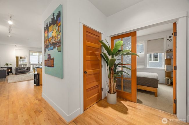 View from the front entry to the living room, coat closet and French doors to the second bedroom | Image 14