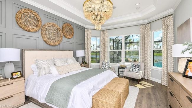 Bedroom featuring a decorative wall, ornamental molding, dark wood-type flooring, an inviting chandelier, and a tray ceiling | Image 12