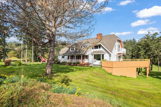 Rear view of property with a chimney, a balcony, a yard, and a shingled roof | Image 7
