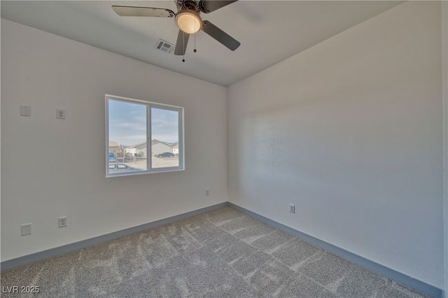 Cozy guest bedroom with ample natural light, plush carpeting, and a spacious closet for comfortable living. | Image 10
