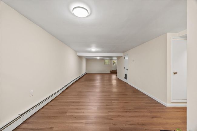 Unfurnished room featuring a baseboard radiator and light wood-type flooring | Image 38