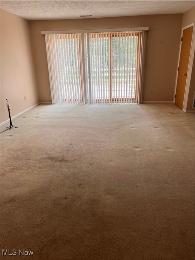 living room with light colored carpet and a textured ceiling | Image 6