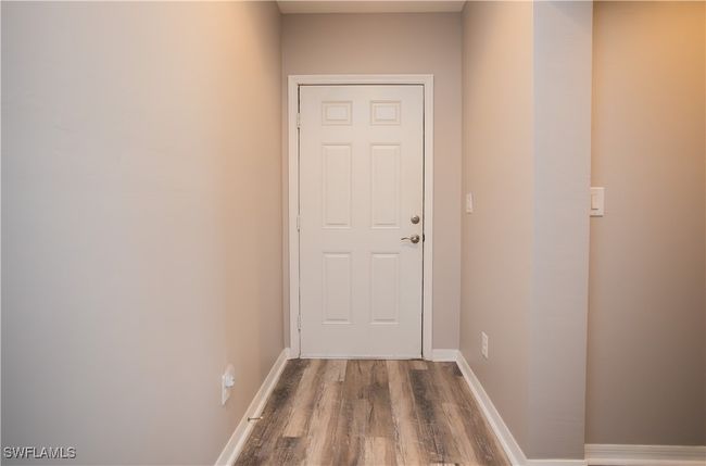 Doorway to outside featuring vinyl wood finished floors and baseboards | Image 19
